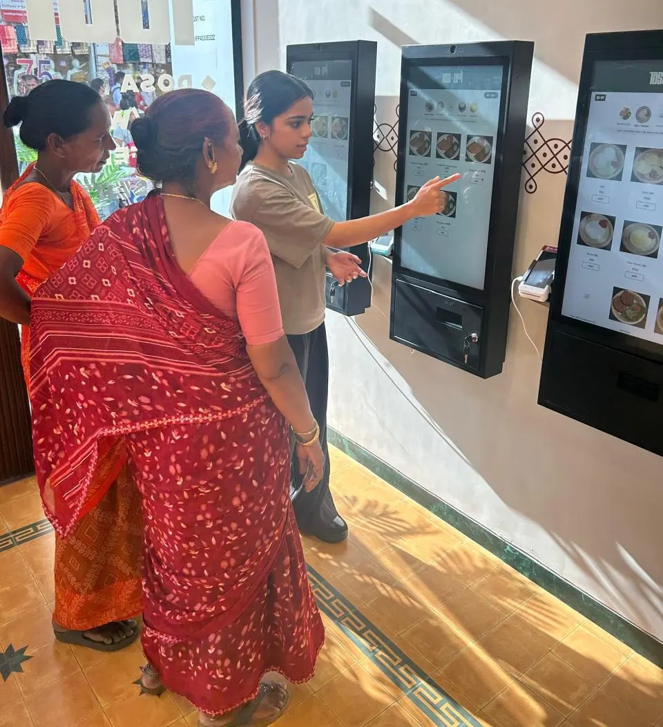 Customers ordering on PALAS wall-mounted kiosks